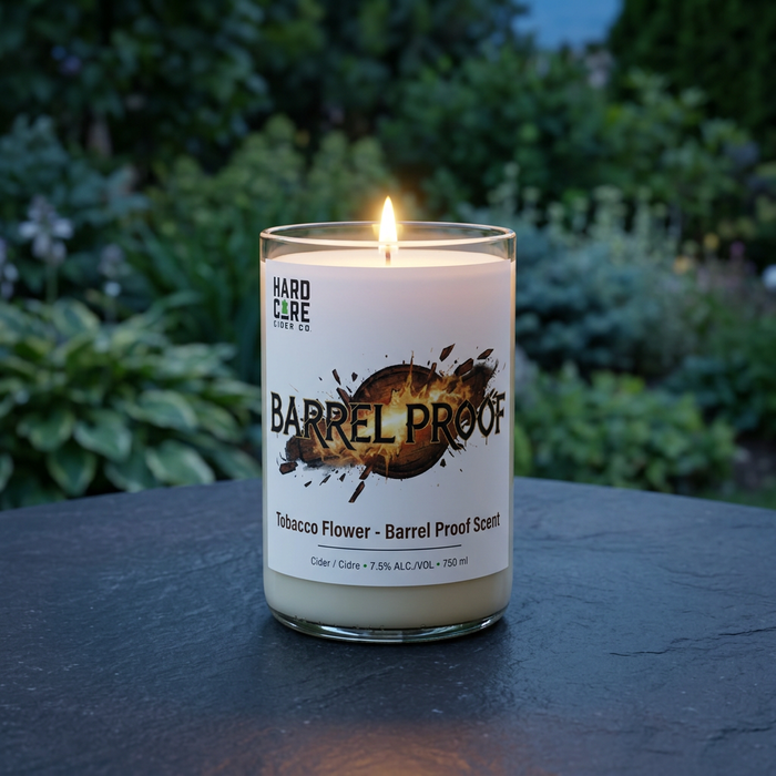 Lit Barrel Proof candle resting on a slate garden table